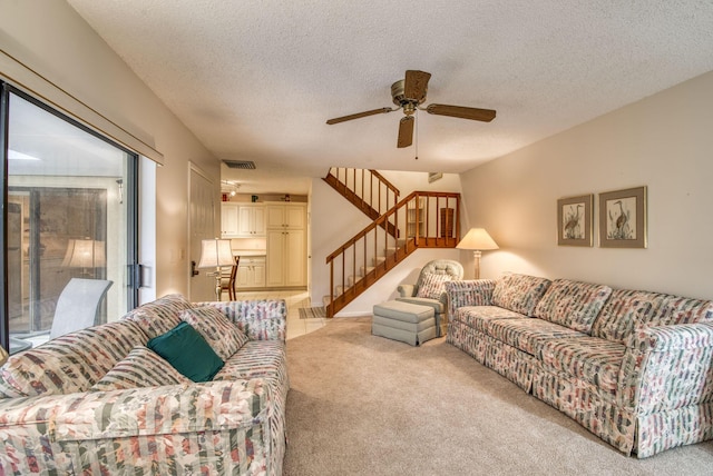 carpeted living room with ceiling fan and a textured ceiling