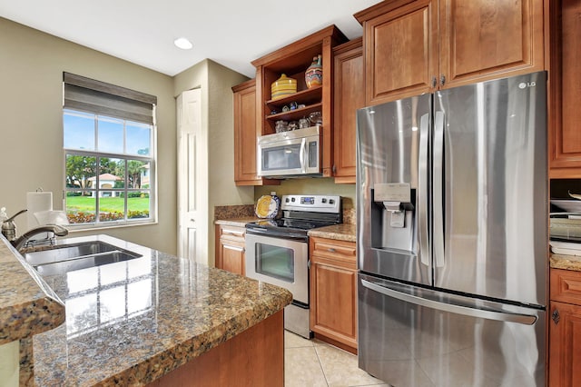 kitchen with light tile patterned flooring, stainless steel appliances, and sink