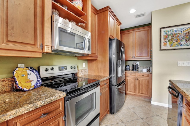 kitchen featuring stainless steel appliances, light stone countertops, and light tile patterned floors