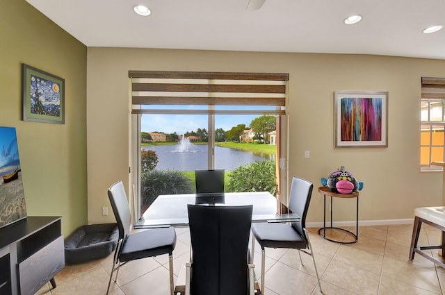 dining space featuring light tile patterned floors and a water view