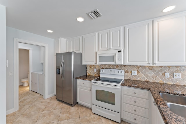 kitchen with washer and dryer, white cabinetry, sink, light tile patterned floors, and white appliances