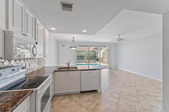 kitchen with sink, white cabinetry, tasteful backsplash, kitchen peninsula, and white appliances