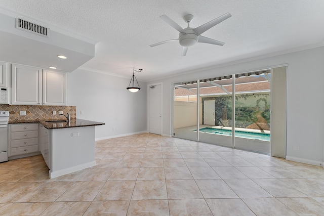 kitchen with light tile patterned flooring, pendant lighting, white cabinetry, kitchen peninsula, and white appliances