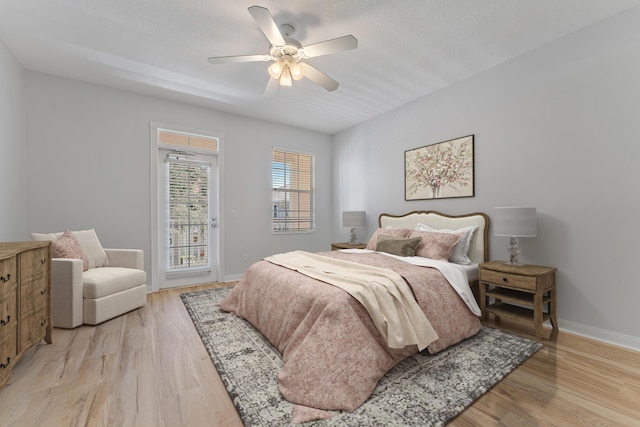 bedroom featuring access to exterior, light hardwood / wood-style flooring, and ceiling fan