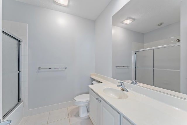 full bathroom with tile patterned floors, toilet, bath / shower combo with glass door, a textured ceiling, and vanity