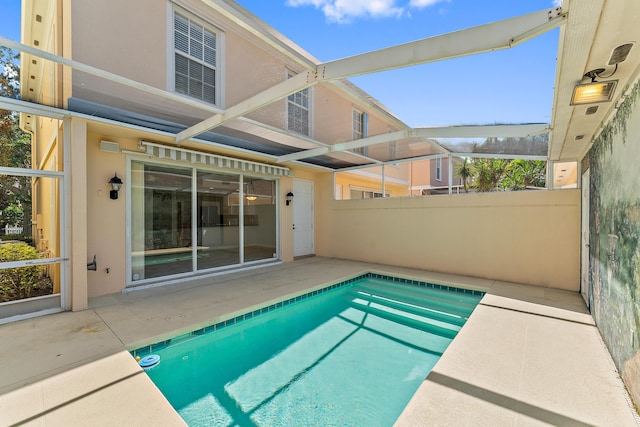 view of swimming pool with glass enclosure and a patio area