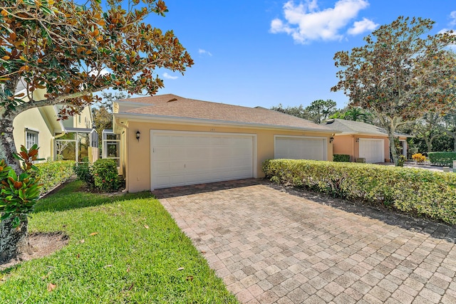 ranch-style home with a garage and a front lawn