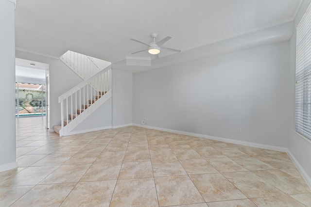 spare room with light tile patterned floors, crown molding, and ceiling fan