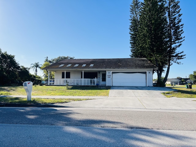 single story home with a garage, a front yard, and a porch