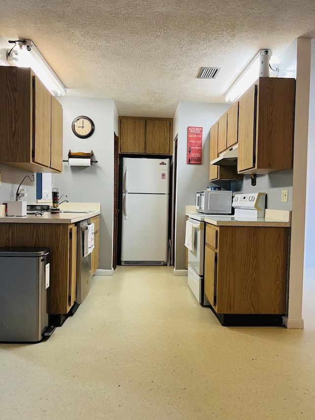 kitchen with stainless steel appliances, sink, and a textured ceiling