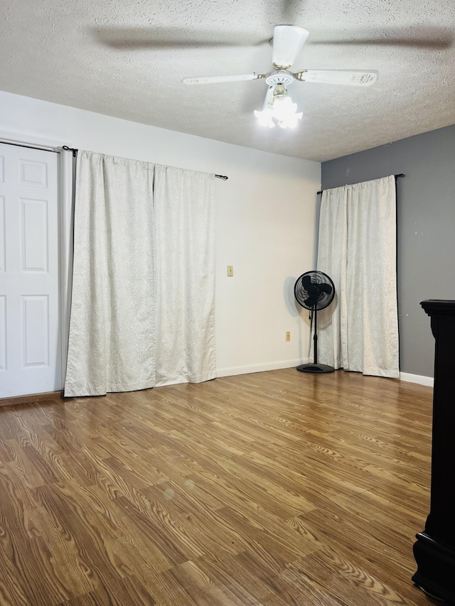 spare room featuring ceiling fan, hardwood / wood-style floors, and a textured ceiling