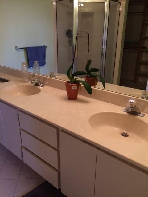 bathroom with vanity, a shower with shower door, and tile patterned floors