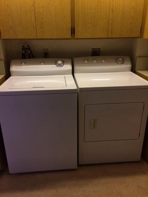 washroom with cabinets and washer and dryer