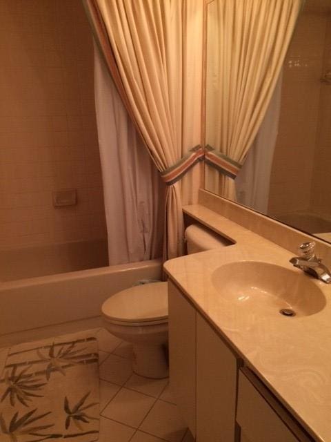 full bathroom featuring vanity, toilet, tile patterned flooring, and shower / bath combo