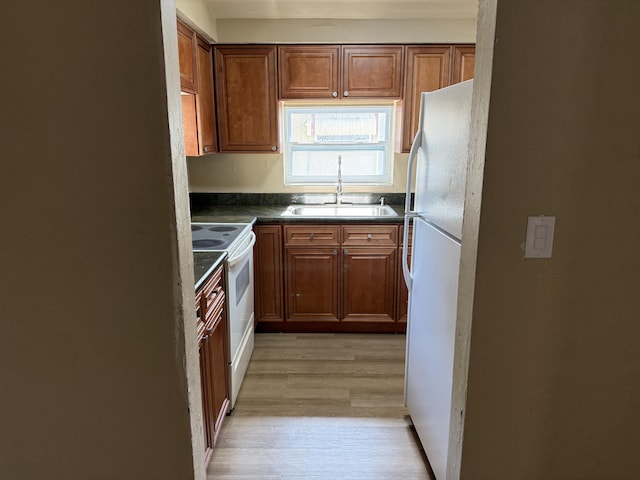 3740 NW 9th St, Fort Lauderdale, FL 33311 - kitchen with a sink, white appliances, light wood-type flooring, dark countertops, and brown cabinets