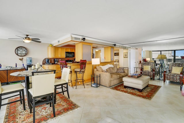 kitchen with a kitchen bar, hanging light fixtures, a tray ceiling, kitchen peninsula, and black appliances