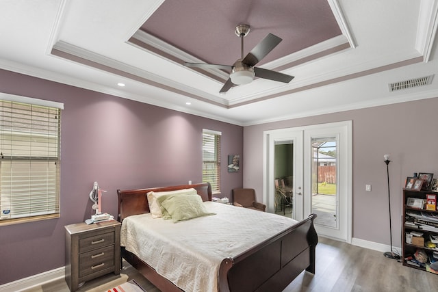 bedroom with french doors, crown molding, light hardwood / wood-style flooring, access to outside, and a raised ceiling