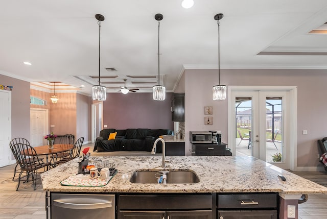 kitchen featuring a kitchen island with sink, sink, crown molding, and hanging light fixtures