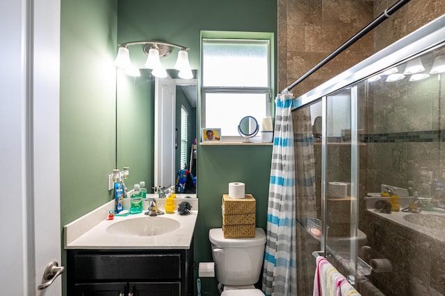 bathroom with vanity, toilet, and tiled shower