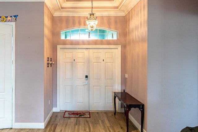 entrance foyer featuring an inviting chandelier, hardwood / wood-style flooring, and ornamental molding