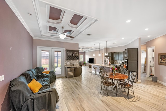 dining area with crown molding, french doors, and light wood-type flooring