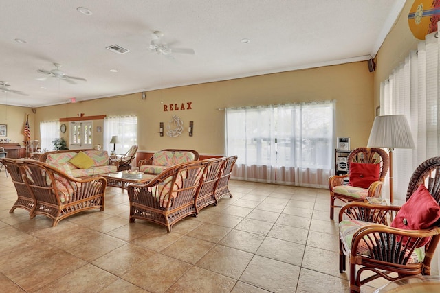 tiled living room featuring ceiling fan and a textured ceiling