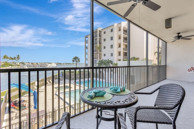 balcony with a water view and ceiling fan