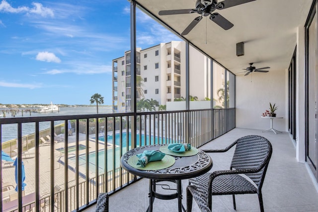 balcony with a water view and ceiling fan