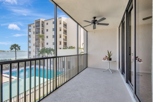 balcony with a water view and ceiling fan