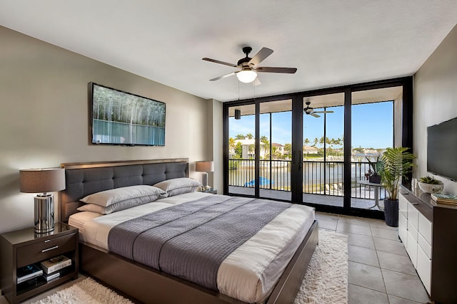 bedroom featuring light tile patterned floors, access to outside, expansive windows, and ceiling fan