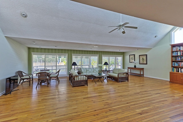 11370 Twelve Oaks Way Unit 217, North Palm Beach, FL 33408 - living area with a textured ceiling, light wood-style floors, a ceiling fan, baseboards, and vaulted ceiling