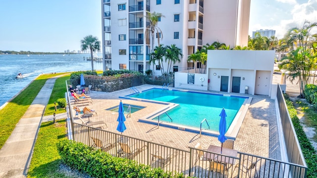 view of pool with a patio and a water view