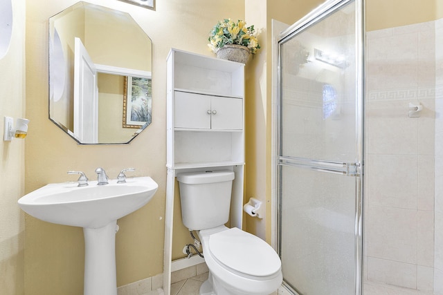 bathroom with tile patterned flooring, sink, toilet, and walk in shower