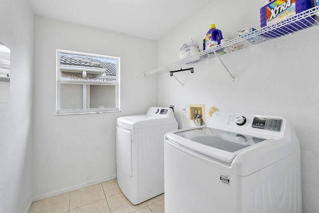 clothes washing area with light tile patterned floors and independent washer and dryer