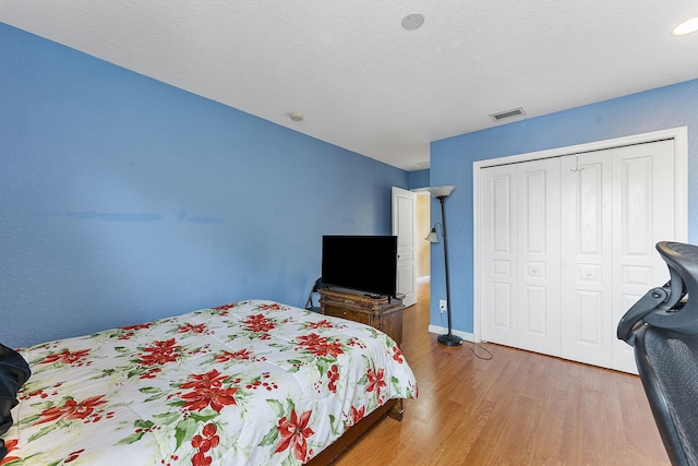 bedroom with wood-type flooring and a closet