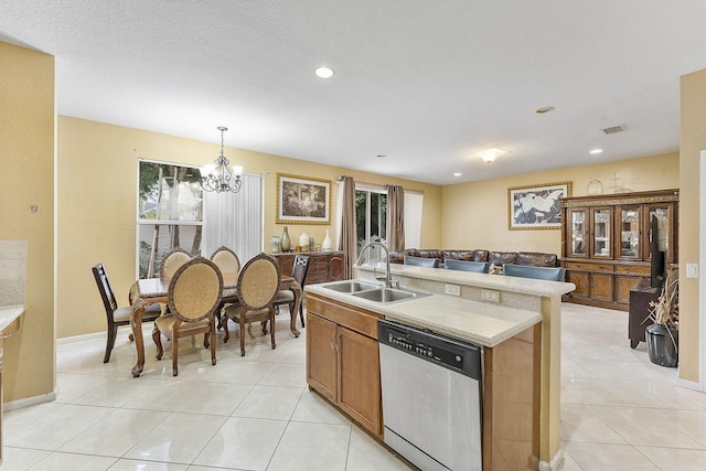 kitchen with light tile patterned flooring, dishwasher, sink, and hanging light fixtures