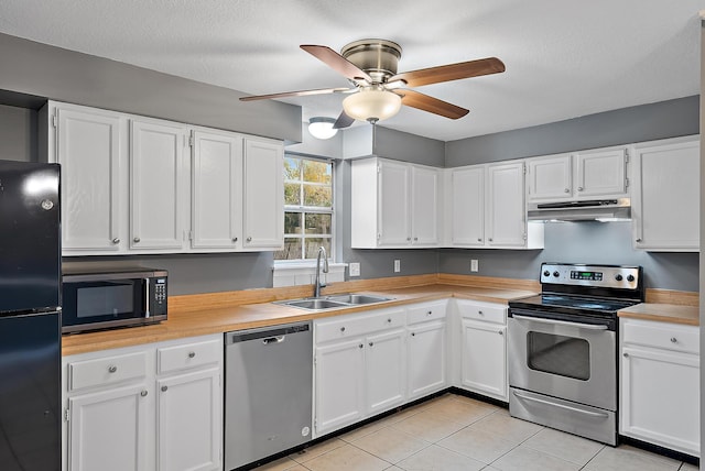 kitchen with sink, white cabinetry, light tile patterned floors, ceiling fan, and stainless steel appliances