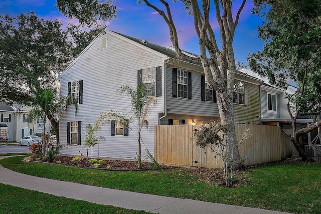 property exterior at dusk with a lawn