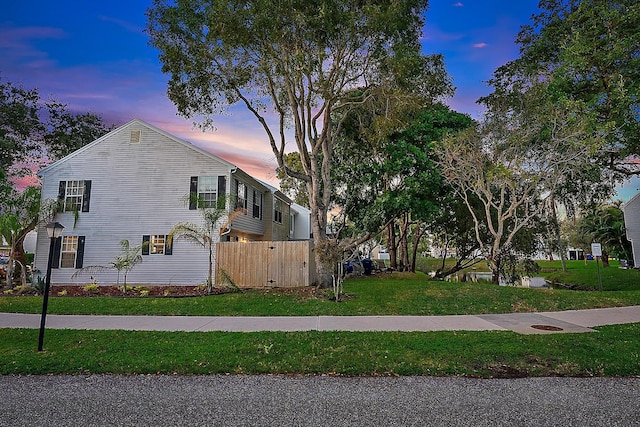 property exterior at dusk featuring a yard