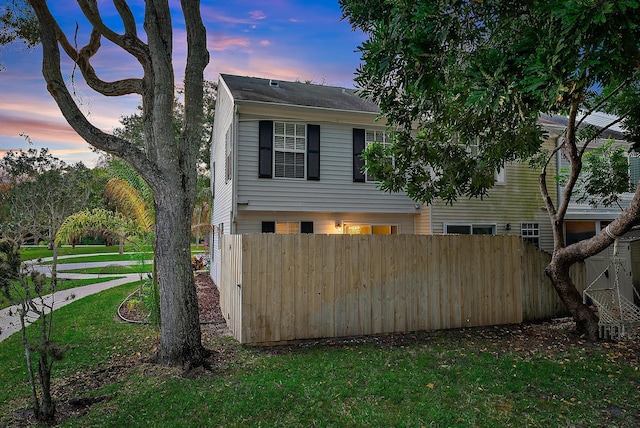 property exterior at dusk with a lawn