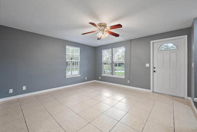 tiled entrance foyer with ceiling fan and a textured ceiling