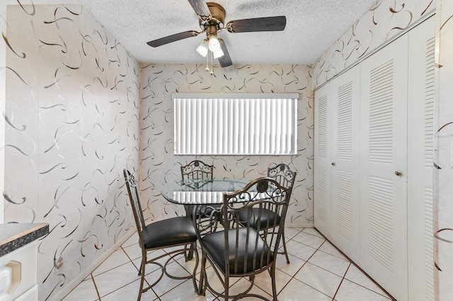 tiled dining room with ceiling fan and a textured ceiling