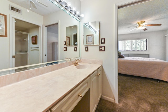 bathroom featuring vanity, a textured ceiling, ceiling fan, and a shower with shower door