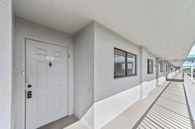 view of exterior entry with a balcony