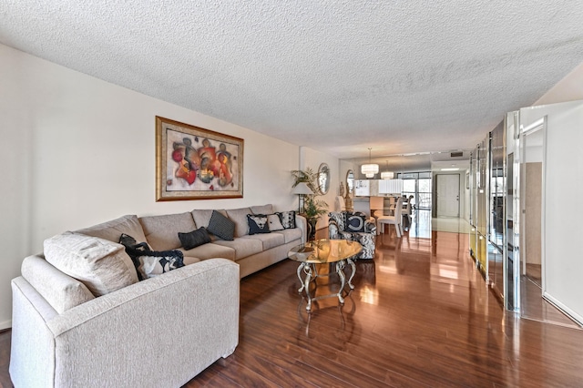 living room featuring dark hardwood / wood-style flooring and a textured ceiling