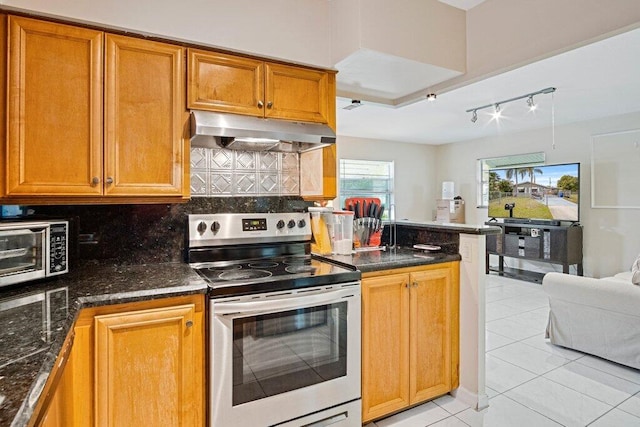 kitchen with tasteful backsplash, dark stone counters, light tile patterned floors, and electric range