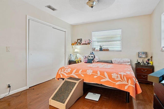 bedroom with hardwood / wood-style flooring, ceiling fan, and a closet