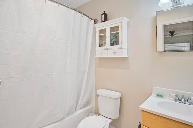 full bathroom featuring vanity, shower / bathtub combination with curtain, and toilet