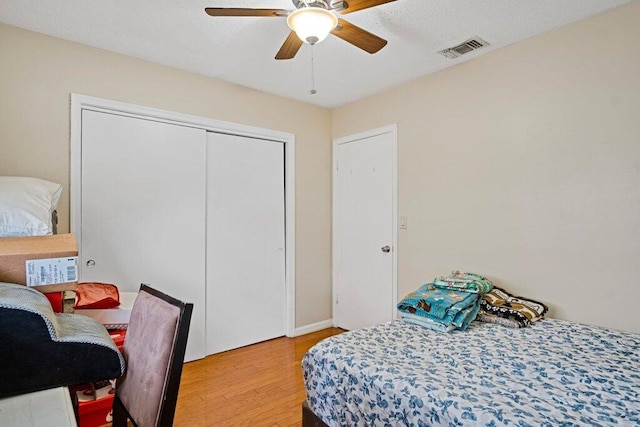 bedroom featuring hardwood / wood-style flooring, ceiling fan, and a closet