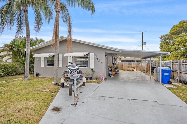 view of front of home featuring a front lawn and a carport